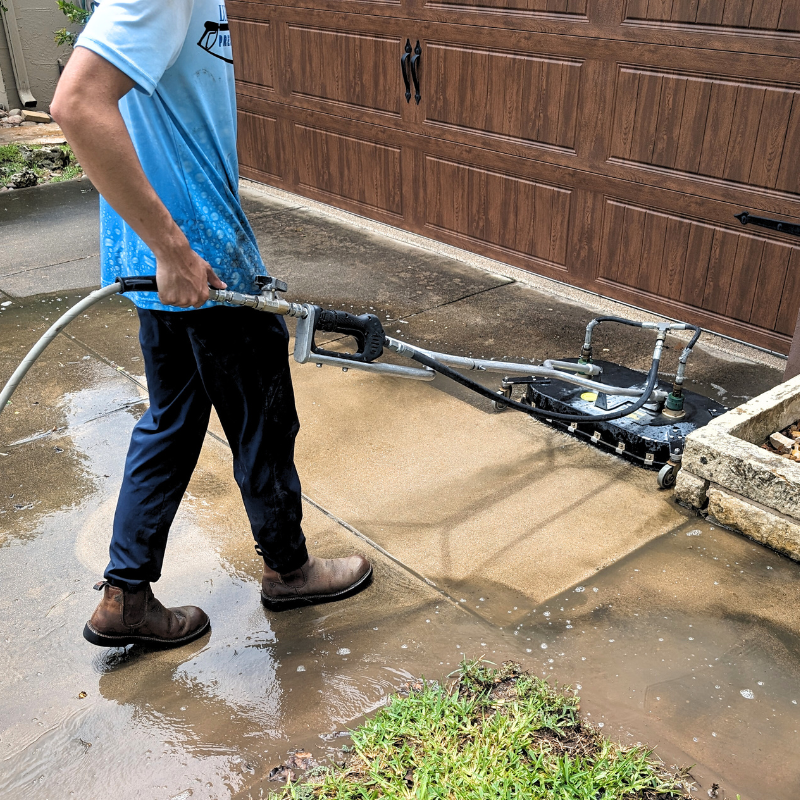 Concrete driveway being power washed by Luke's Pressure Washing