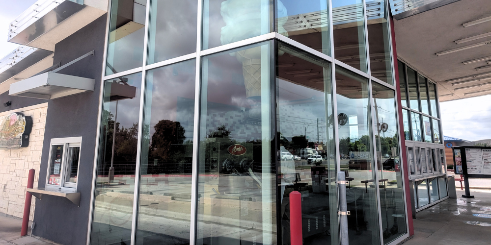 Freshly cleaned restaurant windows reflecting the sky, showing streak-free results from professional exterior window cleaning.
