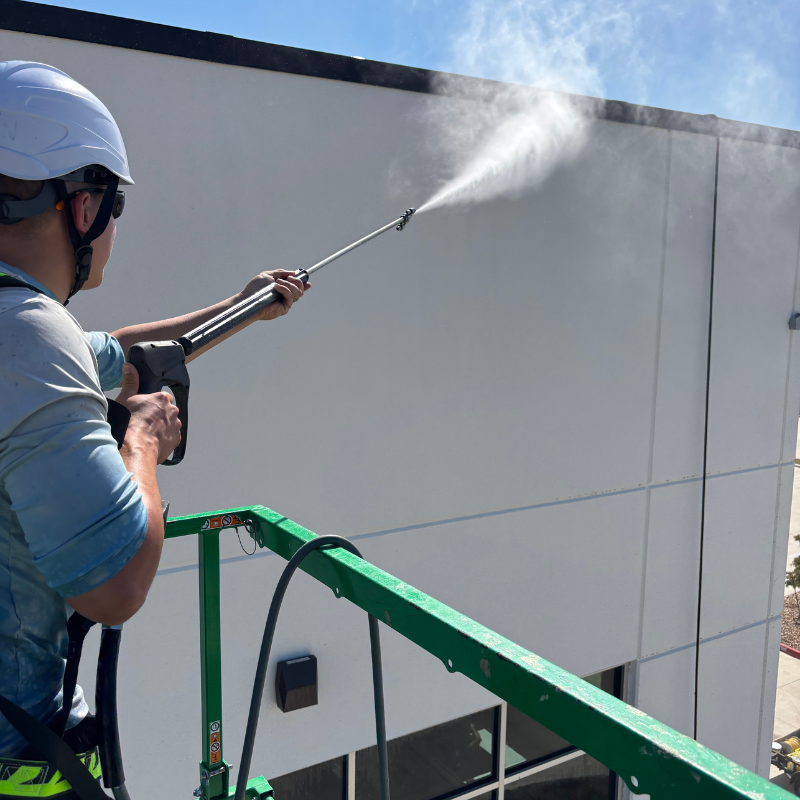Professional commercial pressure washing team cleaning multi-story building exterior in Georgetown, Texas using lift equipment – Luke’s Pressure Washing providing expert building washing services for businesses and commercial properties.