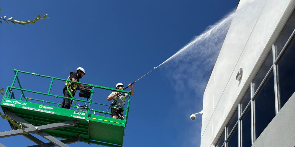 Professional commercial pressure washing team cleaning multi-story building exterior in Georgetown, Texas using lift equipment – Luke’s Pressure Washing providing expert building washing services for businesses and commercial properties.