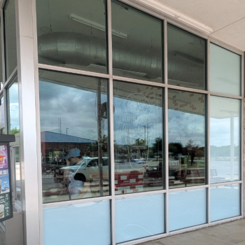 Freshly cleaned restaurant windows reflecting the sky, showing streak-free results from professional exterior window cleaning.